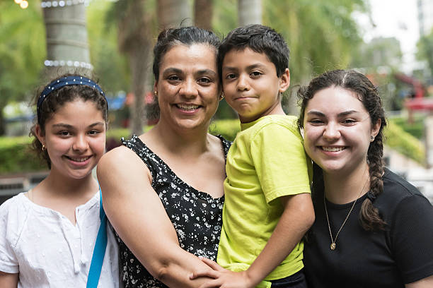 mujer hispana con sus hijos - familia con tres hijos fotografías e imágenes de stock