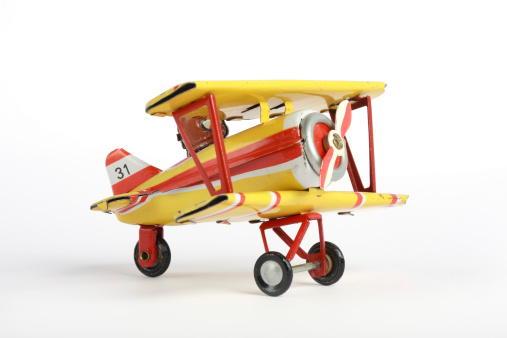Vintage tin toy airplane isolated on white.