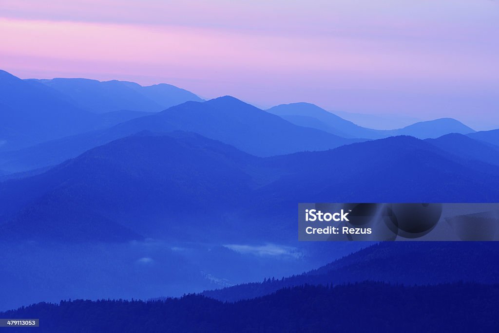 Paisaje de montaña en capas en crepúsculo azul - Foto de stock de Oculto y sobrenatural libre de derechos