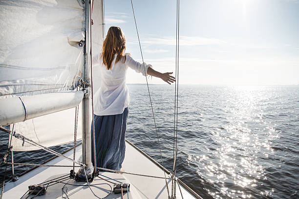 woman staying on sailboat stock photo