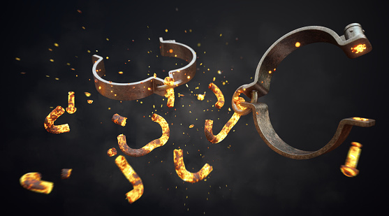 A pair of rugged shackles (handcuffs / manacles) breaking in mid-air. The chain links are glowing hot and exploding outwards in a cloud of sparks and smoke. The metal material looks rugged and rusty and the scene is isolated on a dark background.