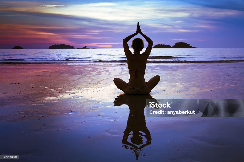 yoga on the beach silhouette of woman practicing yoga Breathing Exercise Stock Photo