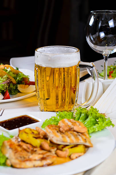 istock Mug of Beer Amidst Plated Dishes on Table 479124504