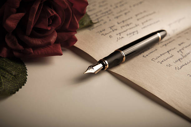 pluma estilográfica en el texto de la hoja de papel con rose - poesía literatura fotografías e imágenes de stock