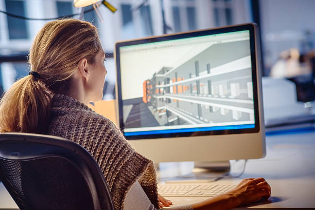 Female architect Working on Computer Mid adult female architect working on a computer in the office. architect office stock pictures, royalty-free photos & images