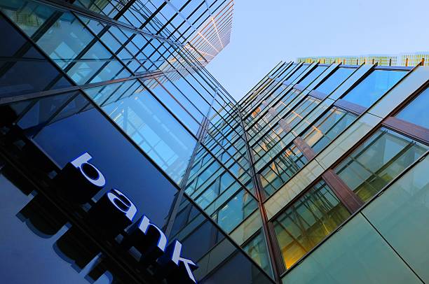 Glass and steel bank corporate building Bank corporate finance building seen from below. The sign "bank" visible close. Sky reflecting in the glass facade. More Facade pictures below large stock pictures, royalty-free photos & images