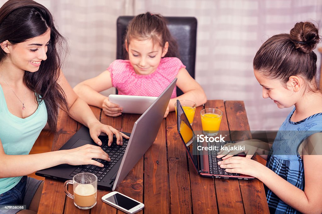 Familia joven usando una variedad de dispositivos digitales CNGLTEC168 - Foto de stock de 10-11 años libre de derechos