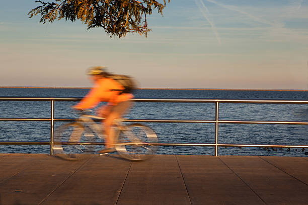 Cyclist becomes a blur along Lake Michigan in Milwaukee Wisconsin stock photo