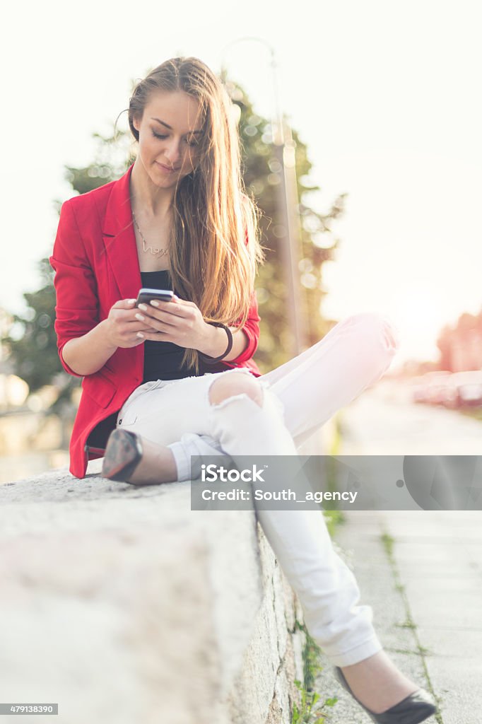 Keeping in touch with her friends Beautiful young woman using mobile phone 20-29 Years Stock Photo