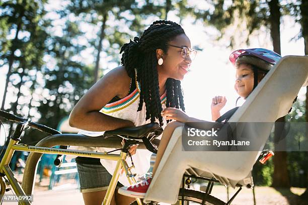 Mom Buckles Up Daughter In Bike Stock Photo - Download Image Now - Child, Bicycle, Mother