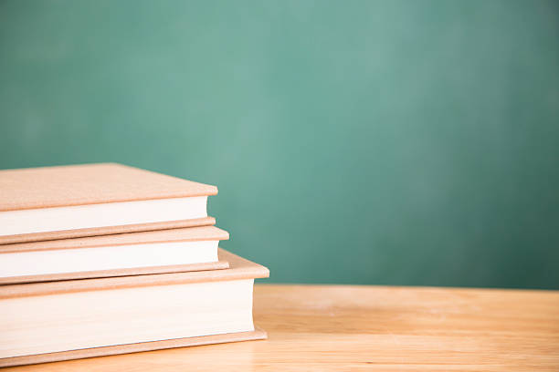 istock Back to school. Textbooks stacked on desk. Chalkboard. 479142304