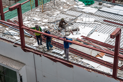 Bangkok, Thailand - July 17, 2011: A small group construction workers demolishing a building In Bangkok, Thailand