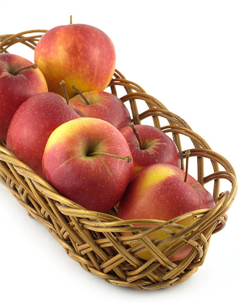 istock Ripe red apples in long brown wicker basket isolated 479152003