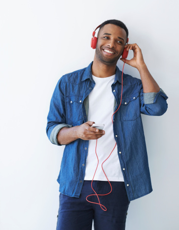 A young african american man wearing a headphones and listening to music against a white background