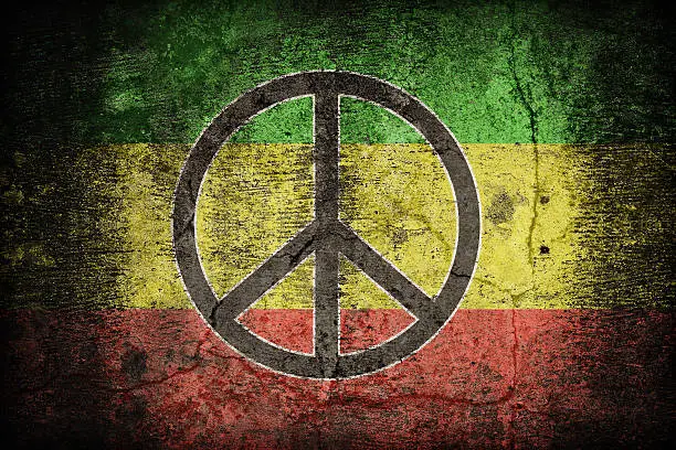Rasta flag pattern with a peace on dirty old concrete wall texture ,retro vintage style