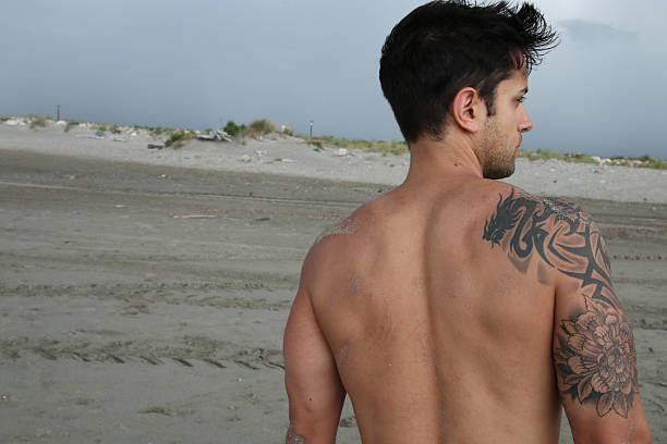 istock tattooed male on the sand 479158094