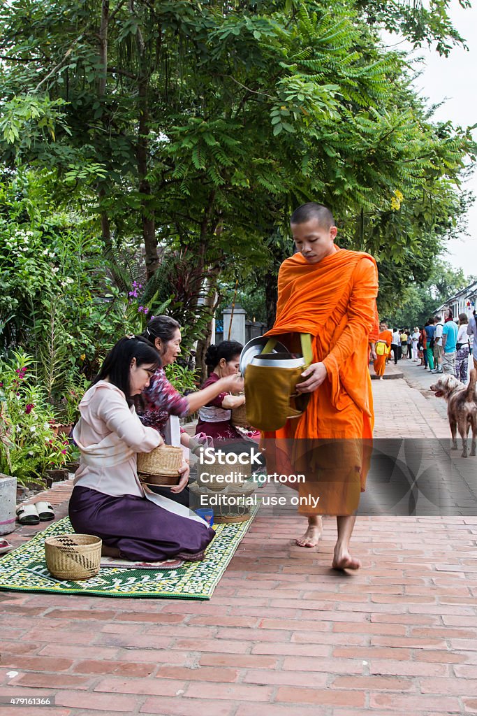 monks walk to collect alms and offerings. Luang Prabang, Laos - October 26, 2014 ; Unidentified monks walk to collect alms and offerings. This procession is held every day in Luang prabang in the early morning. 2015 Stock Photo