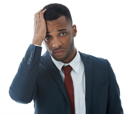 A stressed young businessman with his hand on his head while isolated on white