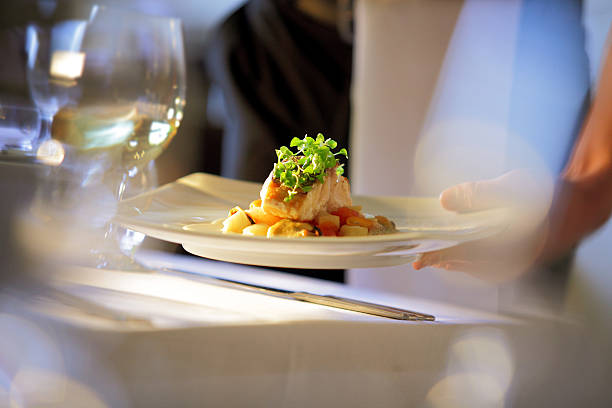 Waiter serving meal at table Soft focus Photo, clean, abstract, contemporary shot of waiter serving meal to a table. waiter stock pictures, royalty-free photos & images