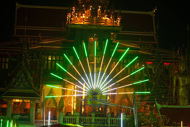 Bangkok, Thailand - March 4, 2015: Capture of buddha statue and thai people outside of temple Wat Lat Phrao in neon light beams. Fullmoon holday night of Makha Bucha festival. Tempe is seated at Wanghin Road.