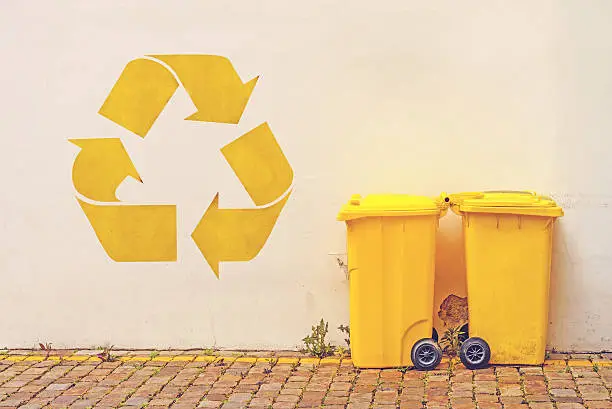 Photo of Two Yellow Recycle Bins on the Street