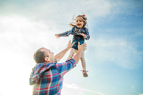 istock dad throws up the girl in the sky 479171100