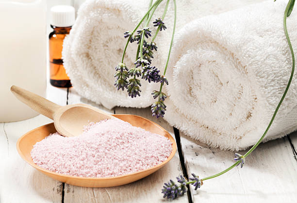 Lavender bath salt spa still-life Wooden bowl of bath mineral with flowers, towels, candle and aromatic essence bath salt photos stock pictures, royalty-free photos & images