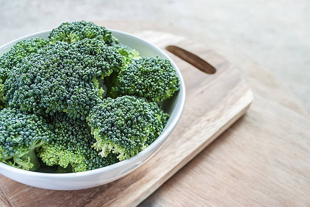 Fresh broccoli vegetable in white bowl on wooden table Fresh broccoli vegetable in white bowl on wooden table cruciferous vegetables stock pictures, royalty-free photos & images