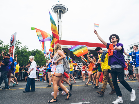 Seattle, Washington, USA- June 29, 2015: This image shows participants in the 2015 Seattle Pride Parade. The Pride Parade celebrates gay rights and attracts large crowds each year. These people are walking along the parade route.