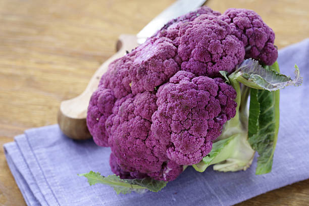 violet brocoli sur une table en bois rustique nature morte - purple cauliflower photos et images de collection