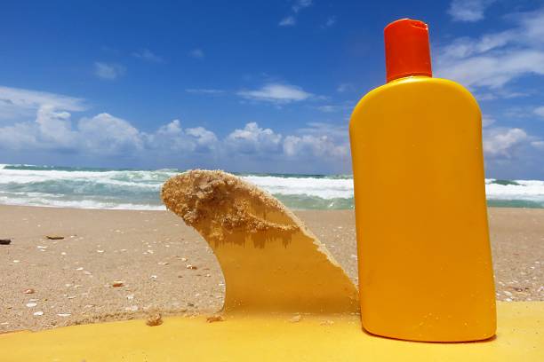 istock Sunscreen and surfboard on the beach 479188100