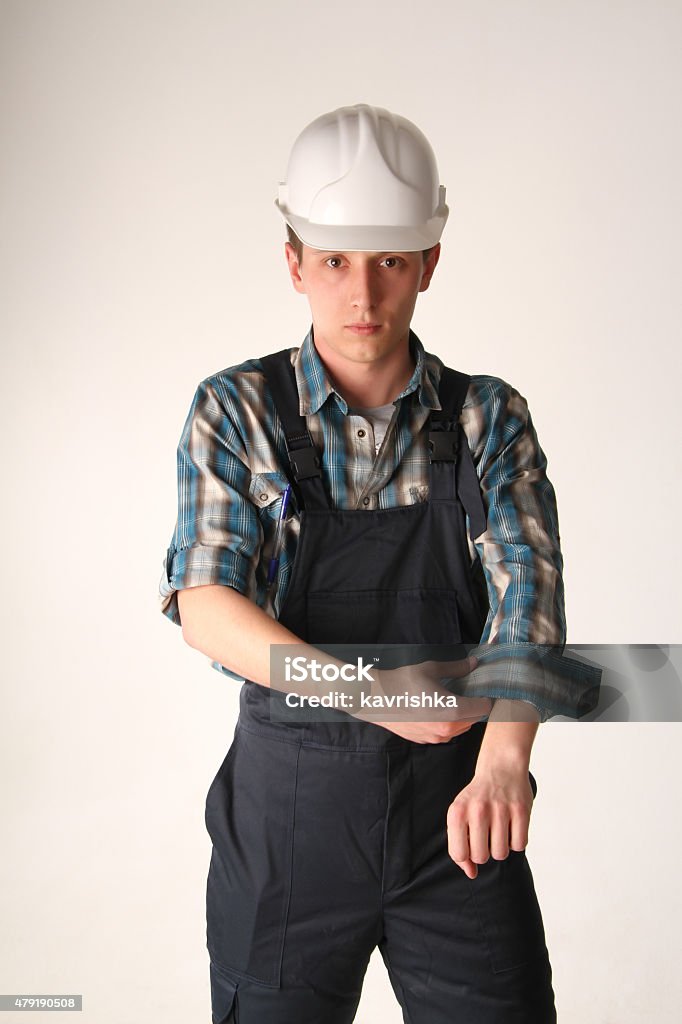 portrait of the young man of the civil engineer the young nice busied man in a helmet and a working form adjusts the sleeves 2015 Stock Photo