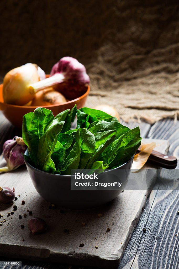 Green spinach leaves Fresh green spinach leaves in a bowl on wooden background 2015 Stock Photo