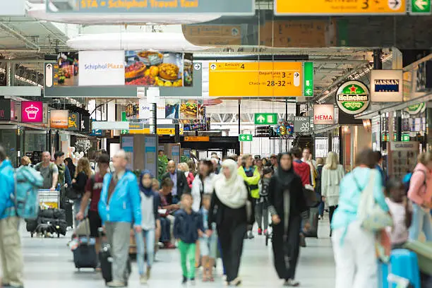 Color image of people walking on the hall between retail stores at Schiphol Airport Amsterdam in the Netherlands.
