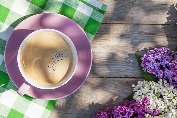 istock Coffee cup and colorful lilac flowers on garden table 479201284