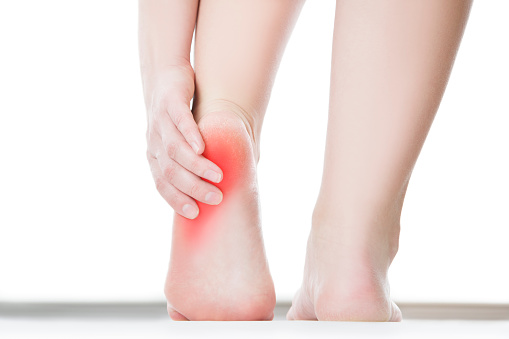 Pain in the foot. Massage of female feet. Pedicures. Isolated on white background.