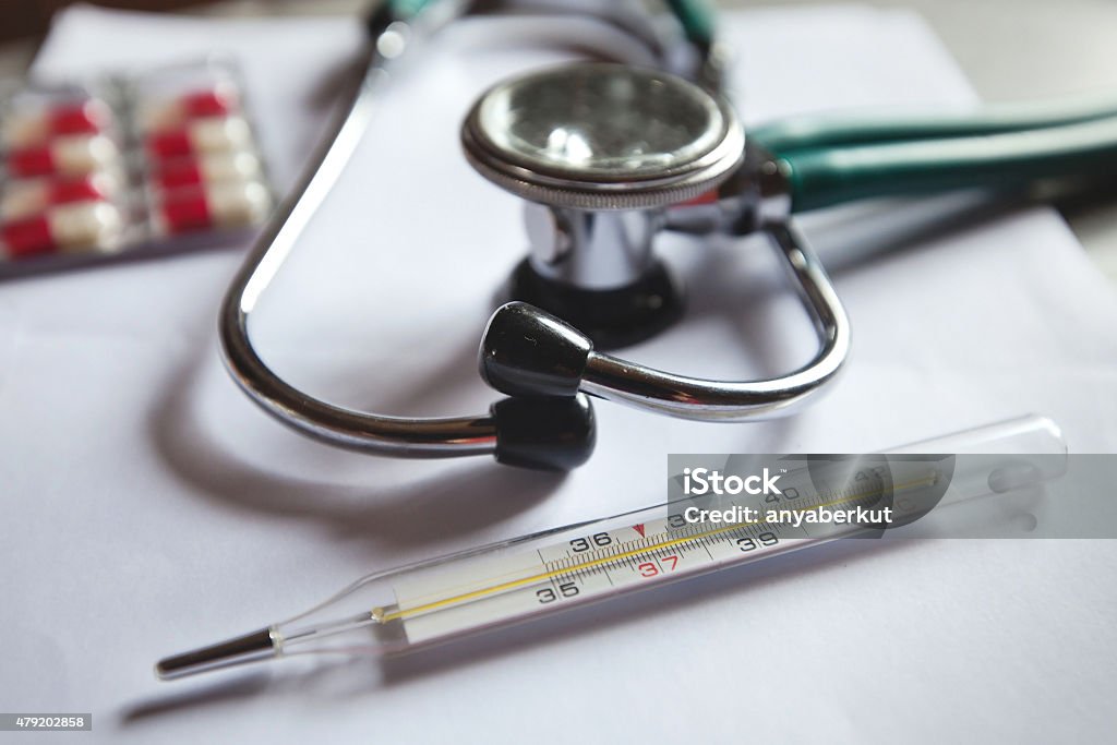 fever and flu thermometer,  pills and stethoscope on the doctor's table Fever Stock Photo