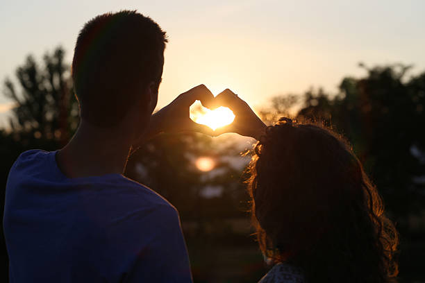 istock young couple making heart at sunset 479203022