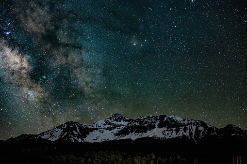 Majestic, snow packed peaks of Mt. Wilson in southern Colorado near Telluride in the middle of the night with details of the starry sky showing the Milky Way.