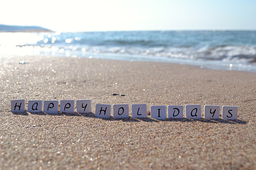 Holiday word sign on the beach sand