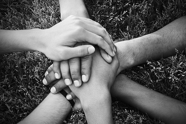 la unidad - human hand holding hands hands clasped group of people fotografías e imágenes de stock