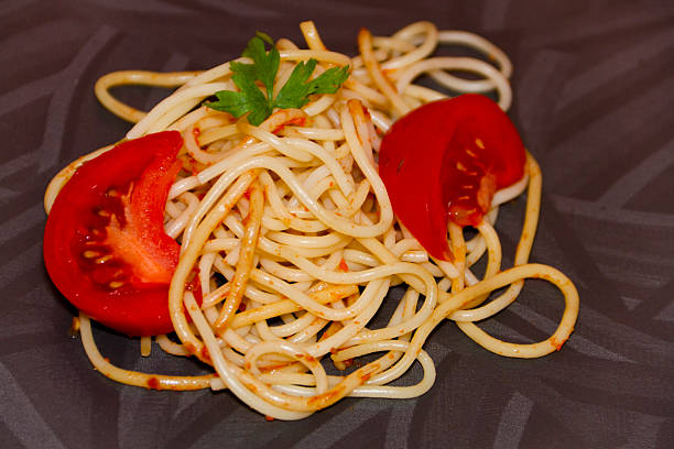 freschi cucinati spaghetti con pomodori e prezzemolo - teigwaren foto e immagini stock