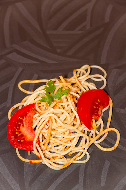 freschi cucinati spaghetti con pomodori e prezzemolo - teigwaren foto e immagini stock