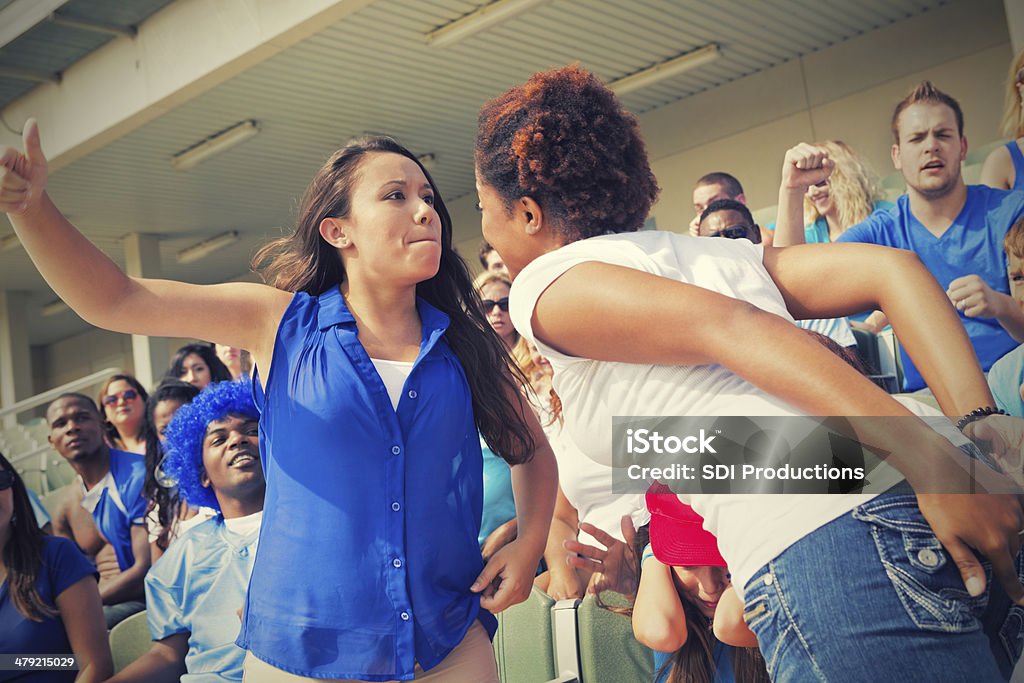 Women fighting during sporting event in stadium Arguing Stock Photo