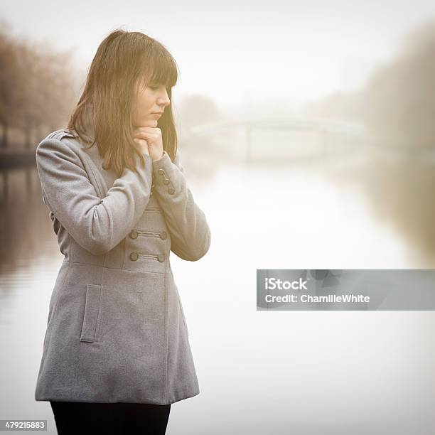 Pretty Sad Girl Near River In A Fog Stock Photo - Download Image Now - Cold Temperature, Fog, Teenager