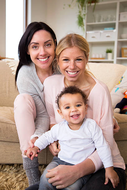 istock Same sex couple smile for the camera with their son 479216124
