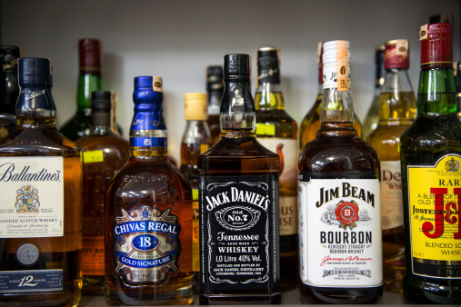 Antalya, Turkey - February 12, 2014:Close-up shot different kinds of alcohol bottles on the market shelf are waiting to be purchased by consumers. The alcohol includes Ballantine's, Chivas Regal, Jack Daniel's, Jim Beam and J+B