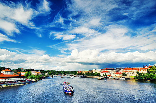 Charles Bridge and Prague Castle over Vltava River with barges and boats at sunset. Perfect end of one beautiful sunny day in Prague. Czech Republic.