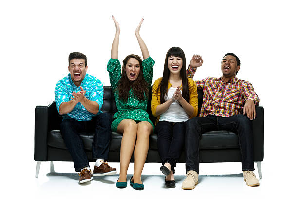 istock Four people cheering and sitting on couch 479227117