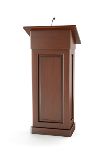 Wooden podium with microphone on a white background.